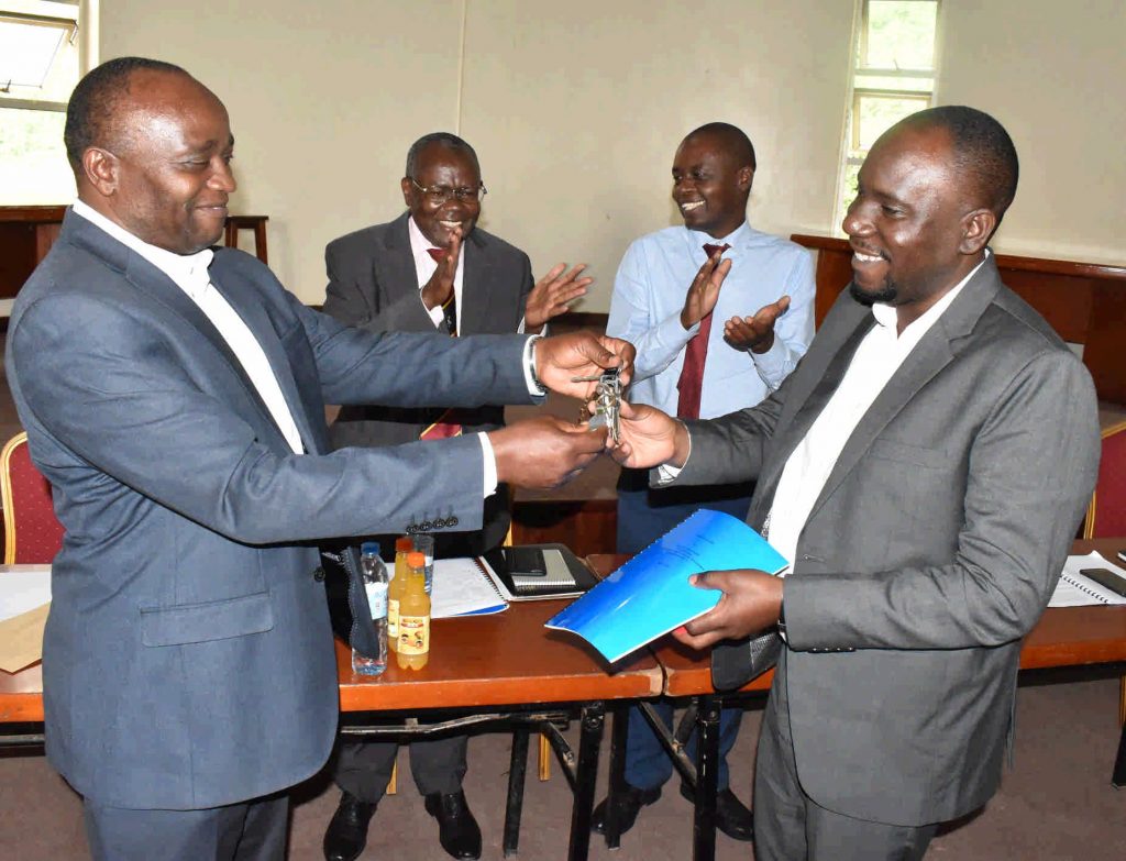  - Dr. Ivan Muzira Mukisa (R) receives the keys to the office from from Prof. Kaaya