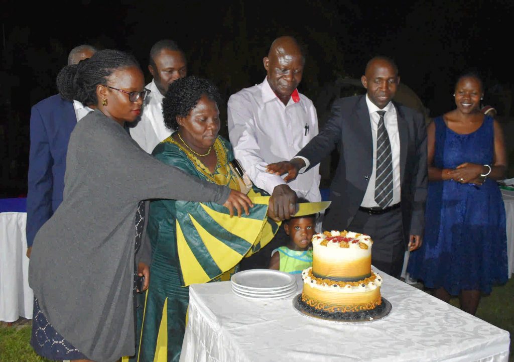  - Dr. JS Tenywa flanked by his family, Principal and Head of department cut the cake